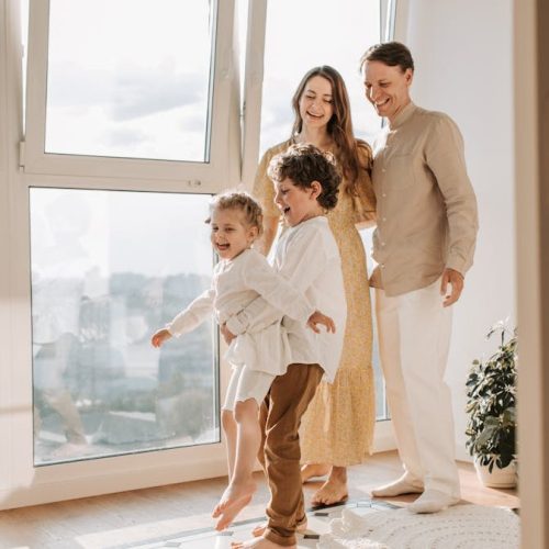 A joyful family of four enjoying time together in a bright, modern living room.