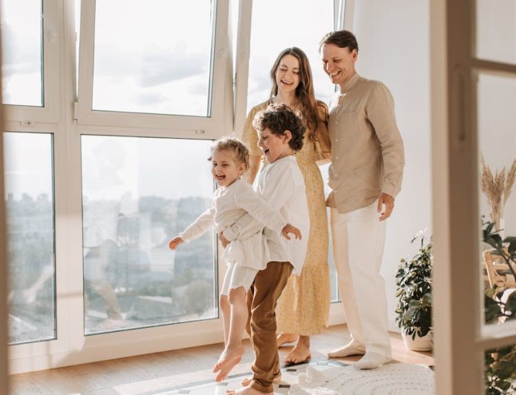 A joyful family of four enjoying time together in a bright, modern living room.
