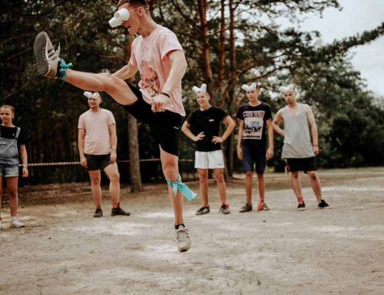 A group of people enjoying an outdoor game with fun eye covers and energetic movements.